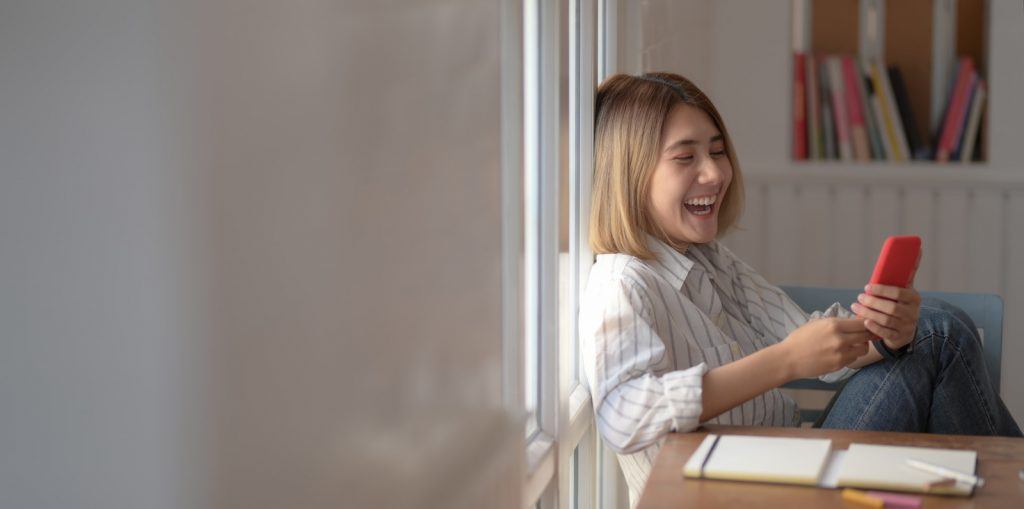 写真-スマホを見て笑っている女性