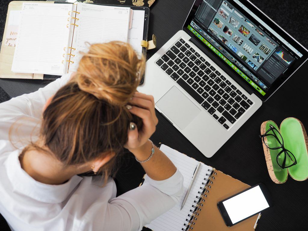 写真-PCの前で頭を抱えている女性