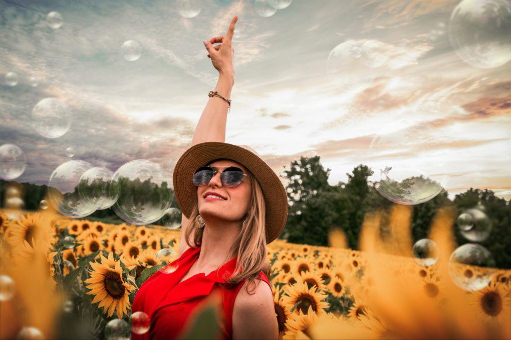 写真-手を上げるひまわりに囲まれた女性