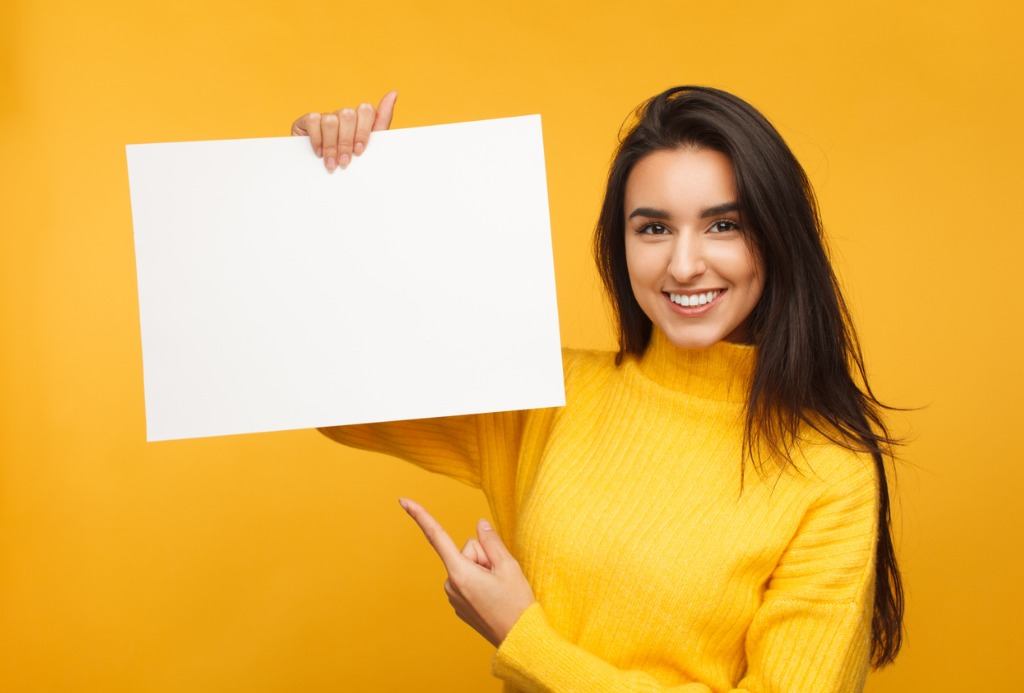 写真-charming-brunette-pointing-at-blank-paper-picture-id936419926