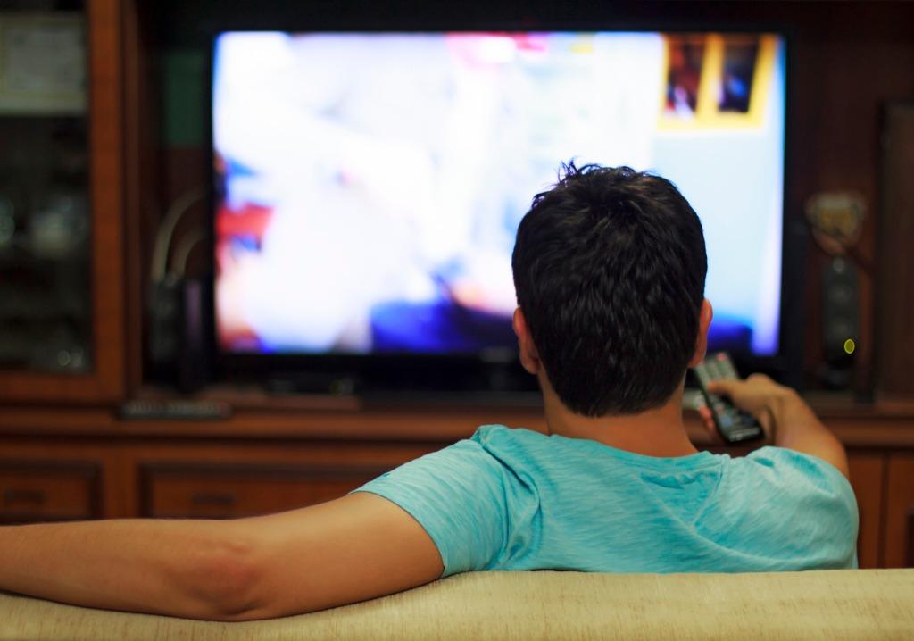 写真-male-watching-television-in-home-living-room-channel-hopping-picture-id1032604300